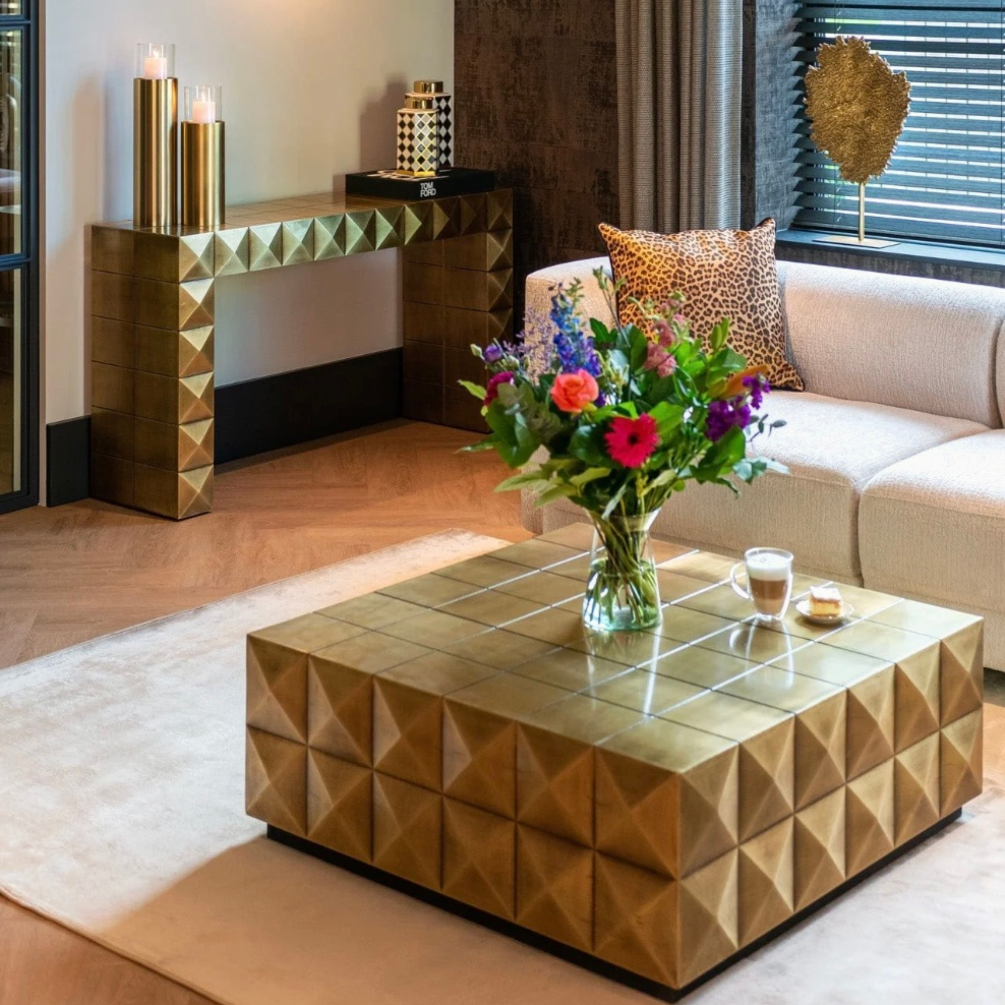 Square coffee table in brushed gold with glass top, crafted from brass for a luxurious and contemporary living room statement.