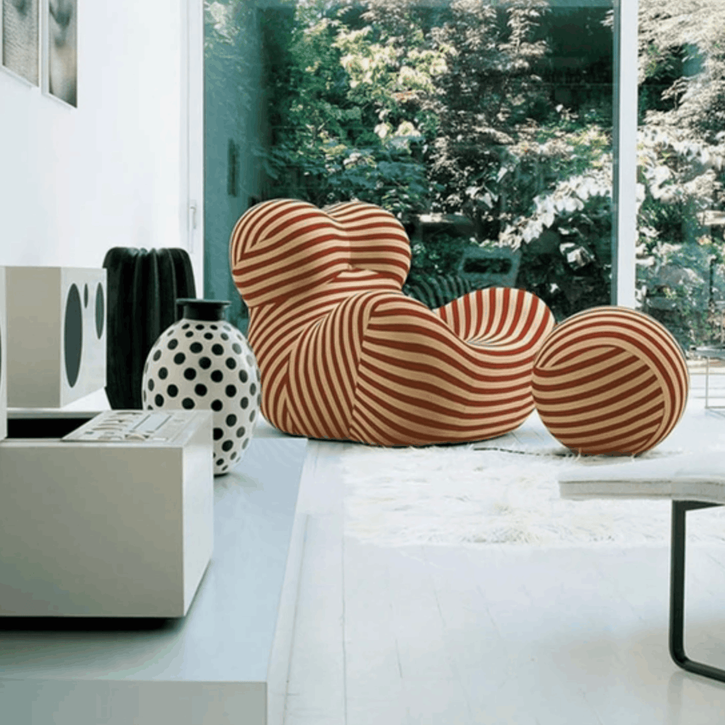 Modern living room with a unique striped chair and a polka dot vase.