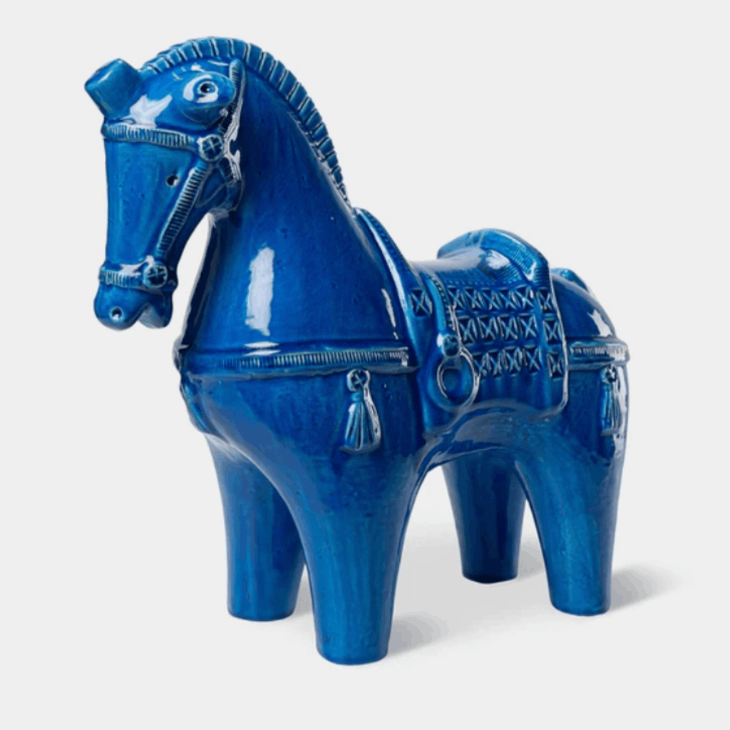 A glossy cobalt blue ceramic horse figurine with tack details, shown against a plain light gray background.