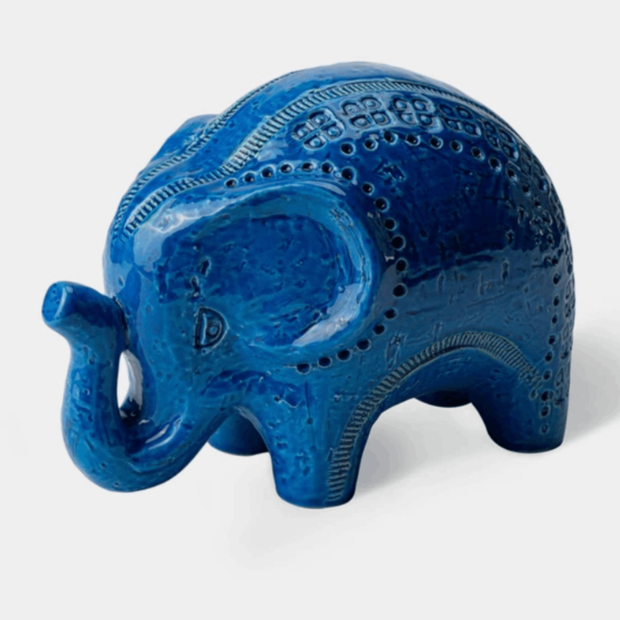 A glossy blue elephant figurine with carved decorative patterns, shown on a light gray background.