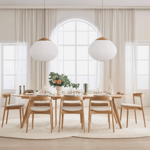 Dining room with wooden table and chairs, large windows, and pendant lights on a Bolia Zen rug.