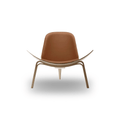 Designed by Hans J. Wegner, the CH07 Shell Chair features a form-pressed veneer shell, leather upholstery, and iconic Scandinavian styling.