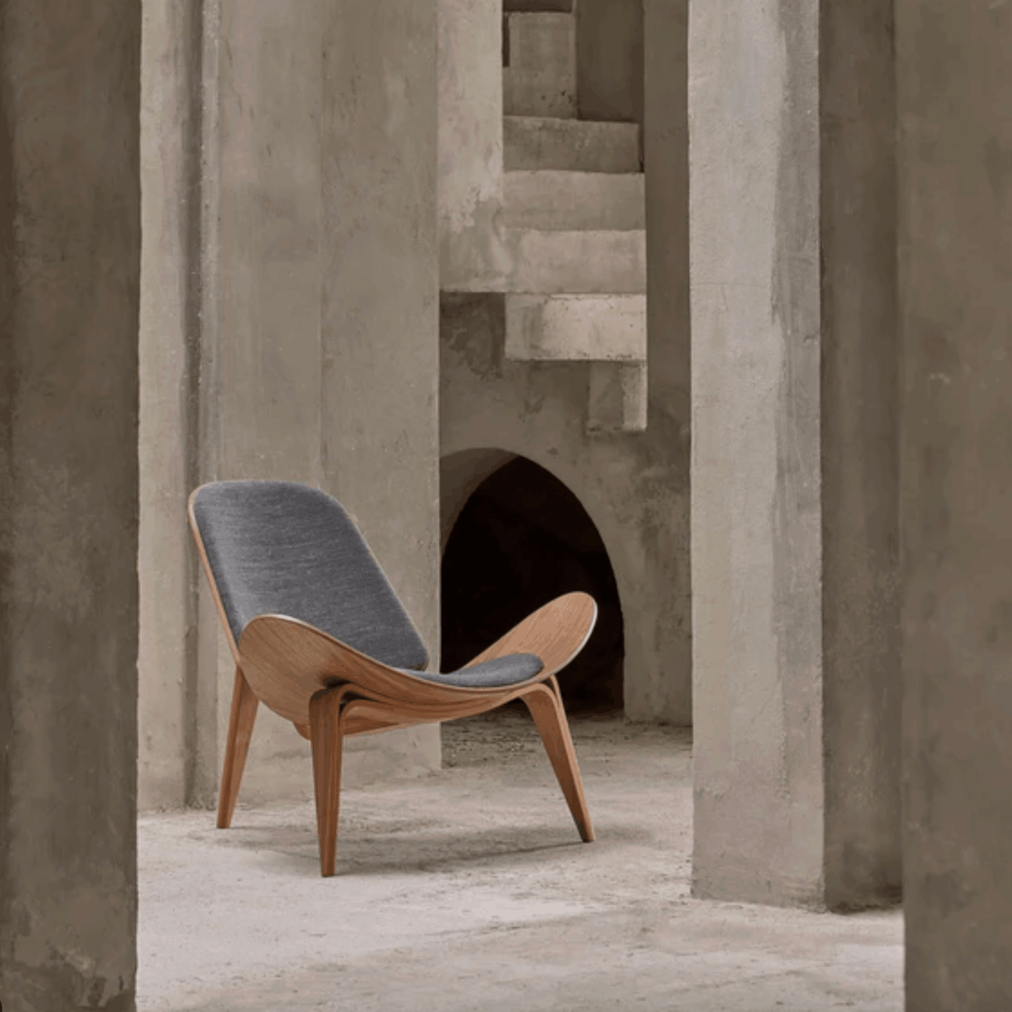 Modern chair with gray cushion in a concrete architectural setting