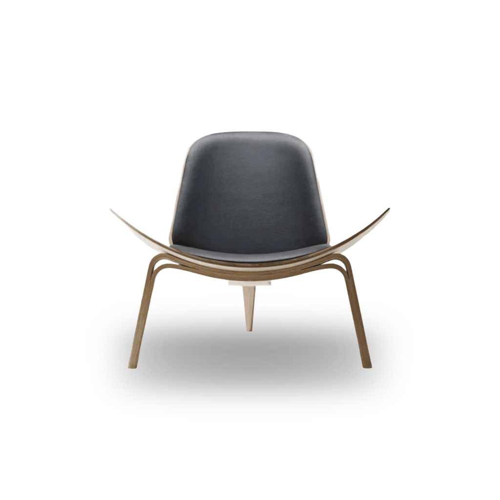Designed by Hans J. Wegner, the CH07 Shell Chair features a form-pressed veneer shell, leather upholstery, and iconic Scandinavian styling.