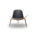 Designed by Hans J. Wegner, the CH07 Shell Chair features a form-pressed veneer shell, leather upholstery, and iconic Scandinavian styling.