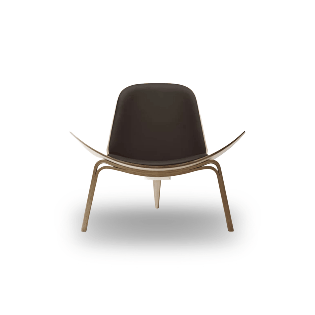 Designed by Hans J. Wegner, the CH07 Shell Chair features a form-pressed veneer shell, leather upholstery, and iconic Scandinavian styling.