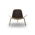 Designed by Hans J. Wegner, the CH07 Shell Chair features a form-pressed veneer shell, leather upholstery, and iconic Scandinavian styling.