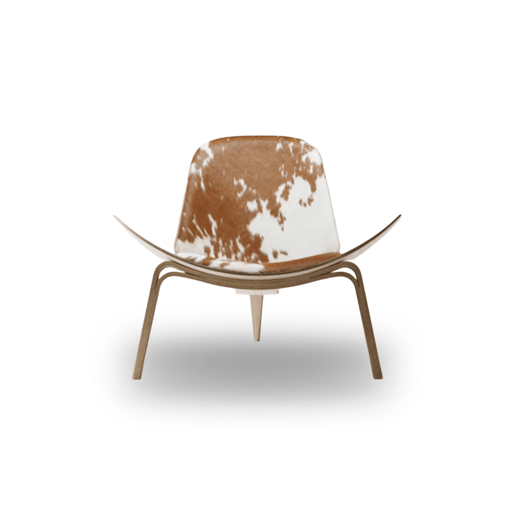Designed by Hans J. Wegner, the CH07 Shell Chair features a form-pressed veneer shell, leather upholstery, and iconic Scandinavian styling.