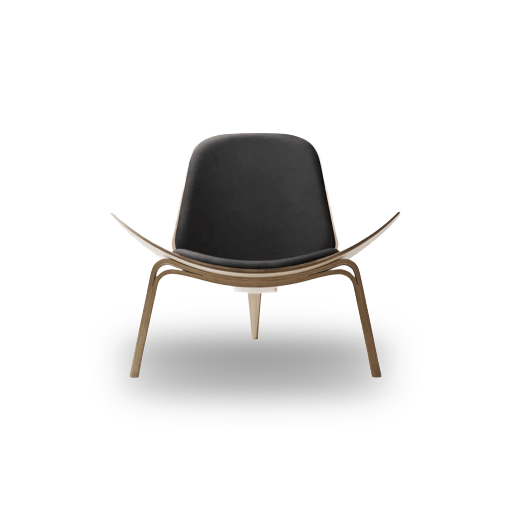 Designed by Hans J. Wegner, the CH07 Shell Chair features a form-pressed veneer shell, leather upholstery, and iconic Scandinavian styling.