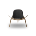 Designed by Hans J. Wegner, the CH07 Shell Chair features a form-pressed veneer shell, leather upholstery, and iconic Scandinavian styling.