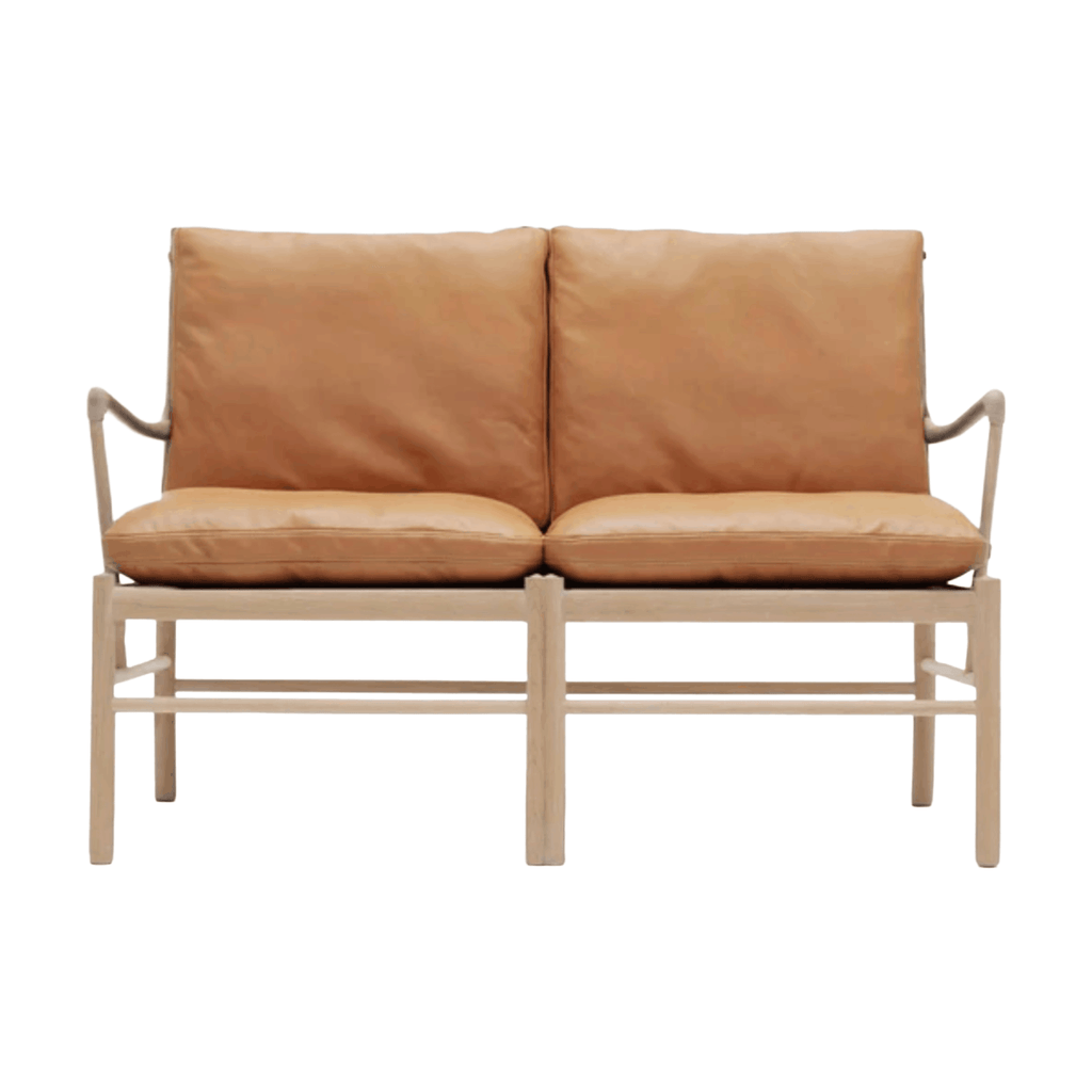 Tan leather sofa with wooden frame on a white background