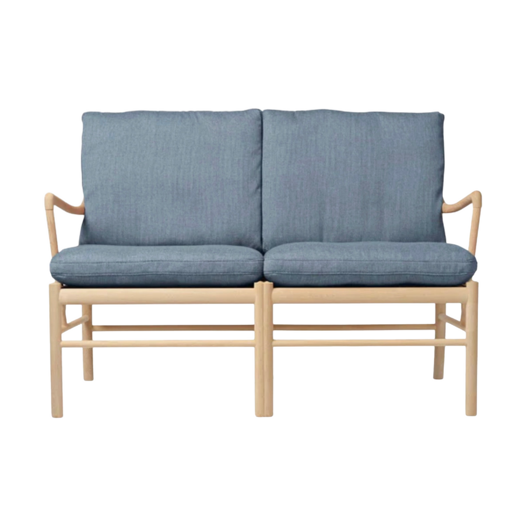 Two-seater sofa with blue cushions and wooden frame on a white background