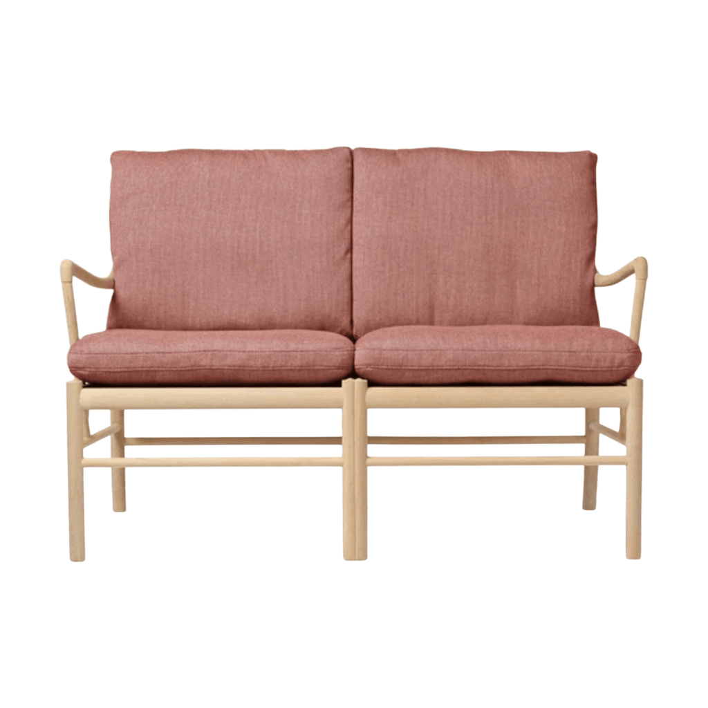 Two-seater sofa with pink cushions and wooden frame on a white background