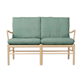 Two-seater sofa with green cushions and wooden frame on a white background