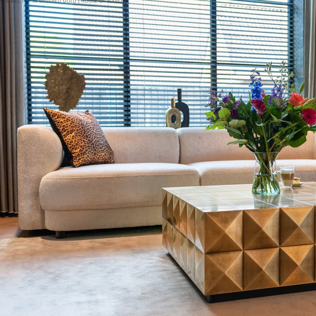 Square coffee table in brushed gold with glass top, crafted from brass for a luxurious and contemporary living room statement.