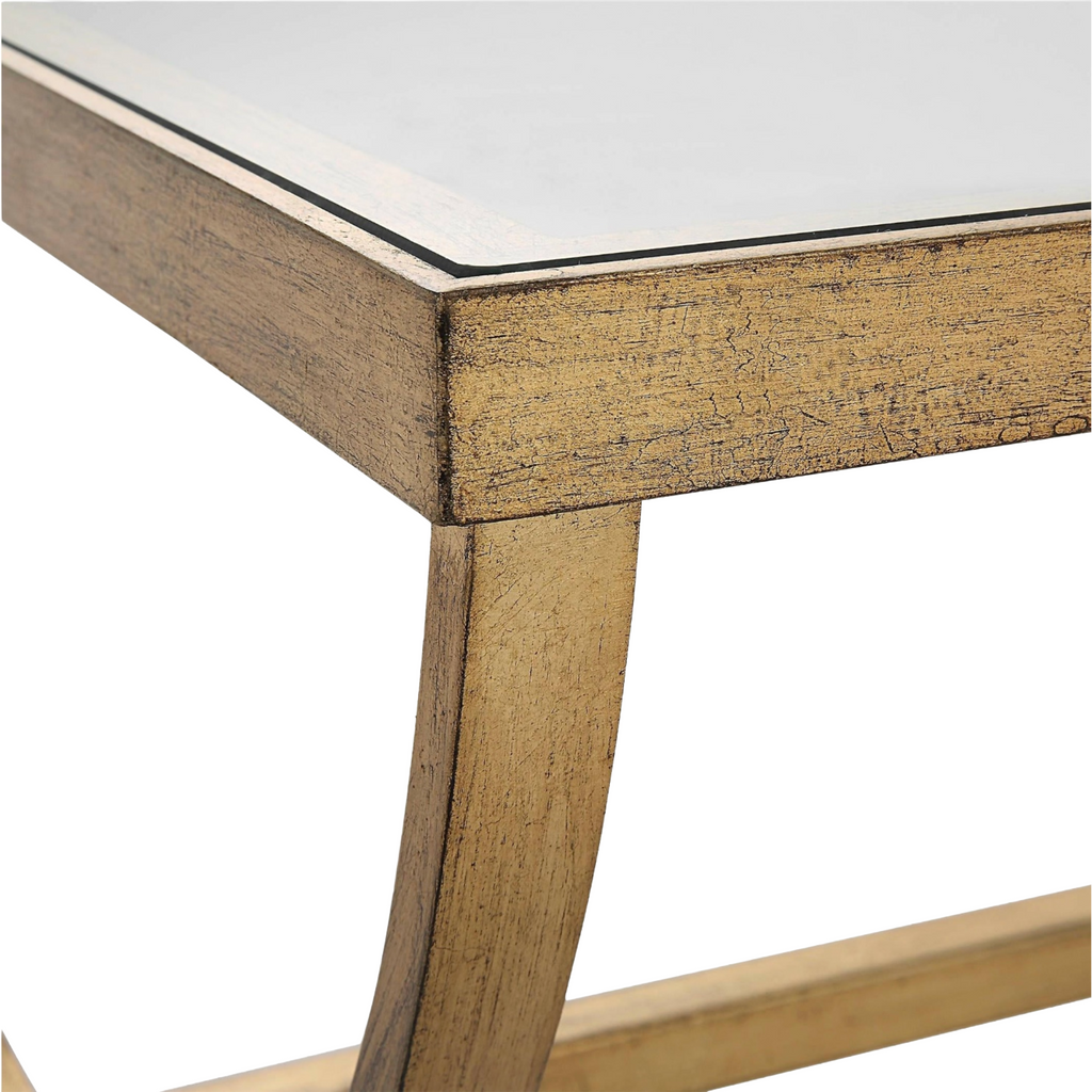 Close up elegant crescent coffee table featuring hand-forged iron in antique gold with tempered glass top, ideal for modern living rooms.