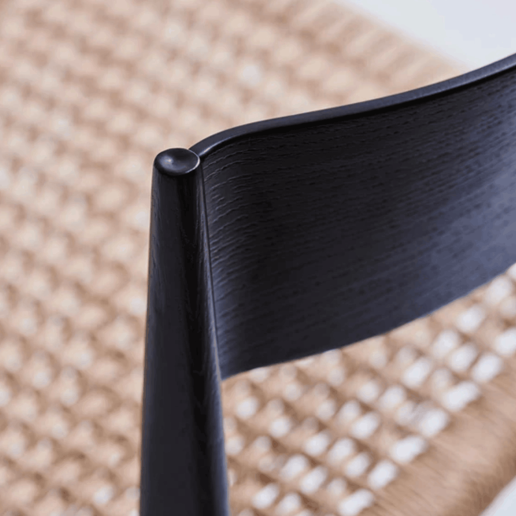 Close-up of the DK3 Pia Chair features solid walnut construction, a hand-woven paper cord seat, and refined Scandinavian styling.