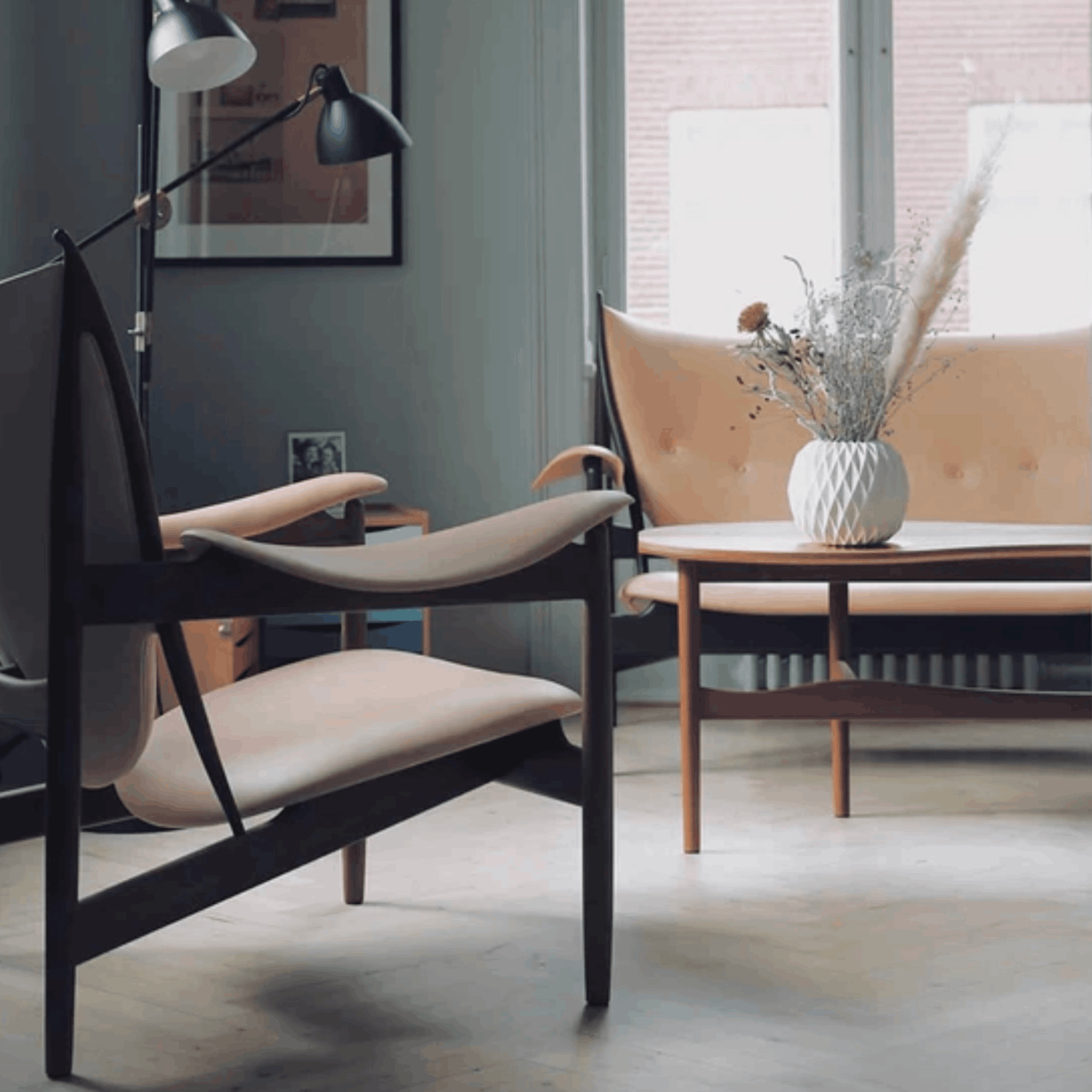 Modern living room with a black chair, beige sofa, and decorative elements.