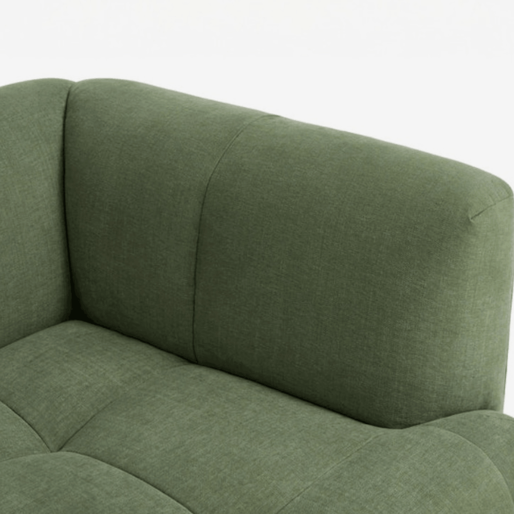 Close-up of an olive green upholstered sofa corner showing the fabric texture and padded armrests against a plain white background.