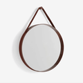 A contemporary round wall mirror by HAY featuring a minimalist steel strap design, perfect for bedrooms, bathrooms, and hallways.