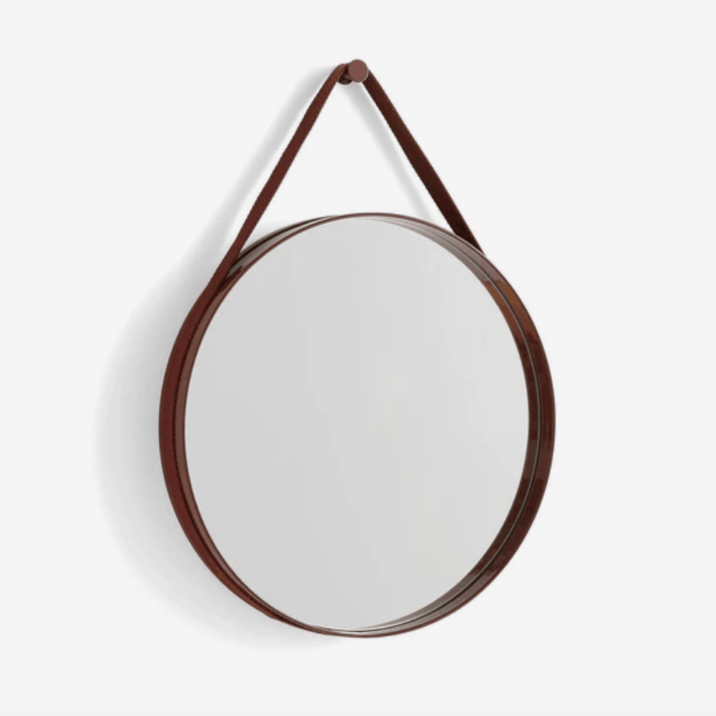 A contemporary round wall mirror by HAY featuring a minimalist steel strap design, perfect for bedrooms, bathrooms, and hallways.