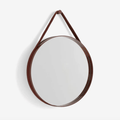 A contemporary round wall mirror by HAY featuring a minimalist steel strap design, perfect for bedrooms, bathrooms, and hallways.