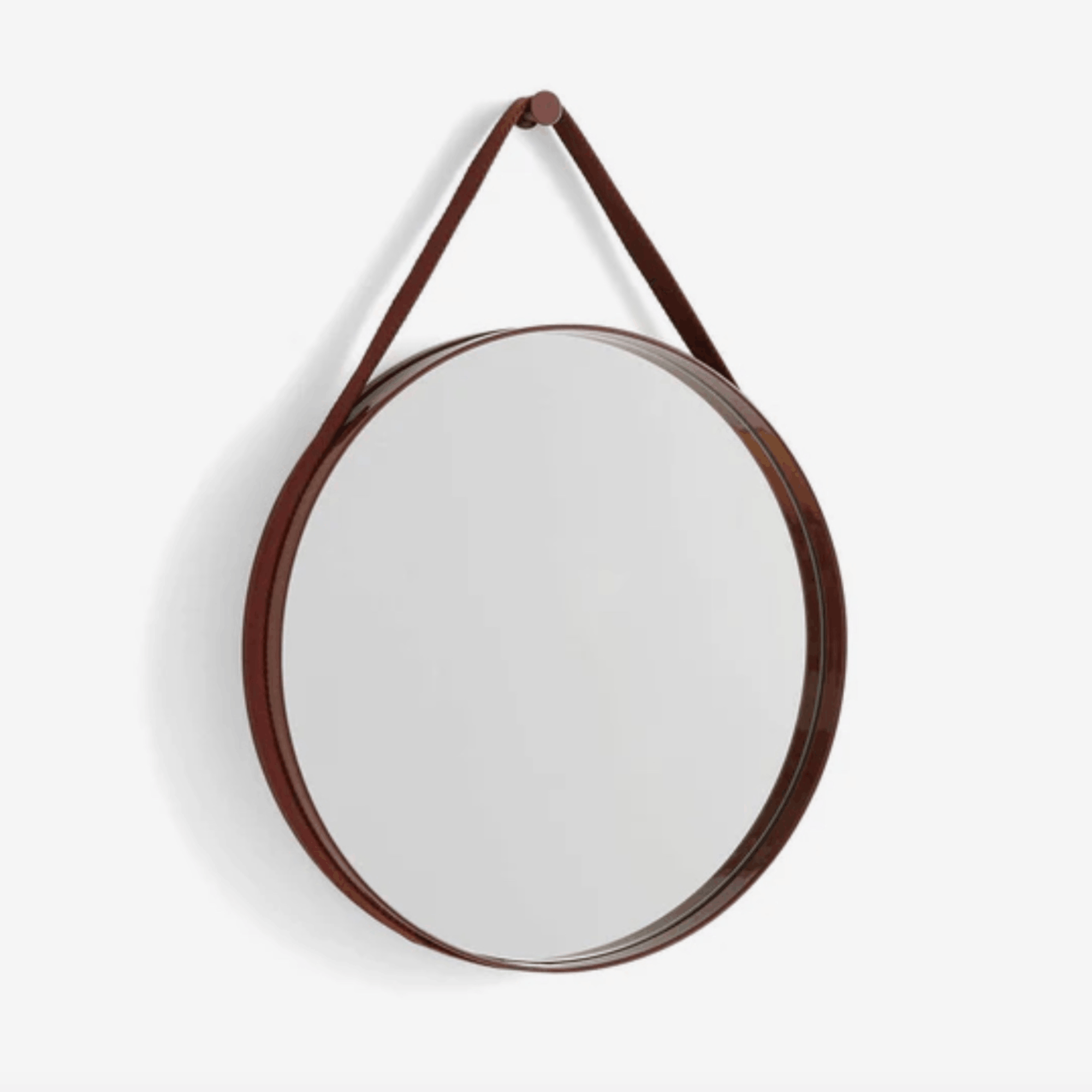 A contemporary round wall mirror by HAY featuring a minimalist steel strap design, perfect for bedrooms, bathrooms, and hallways.