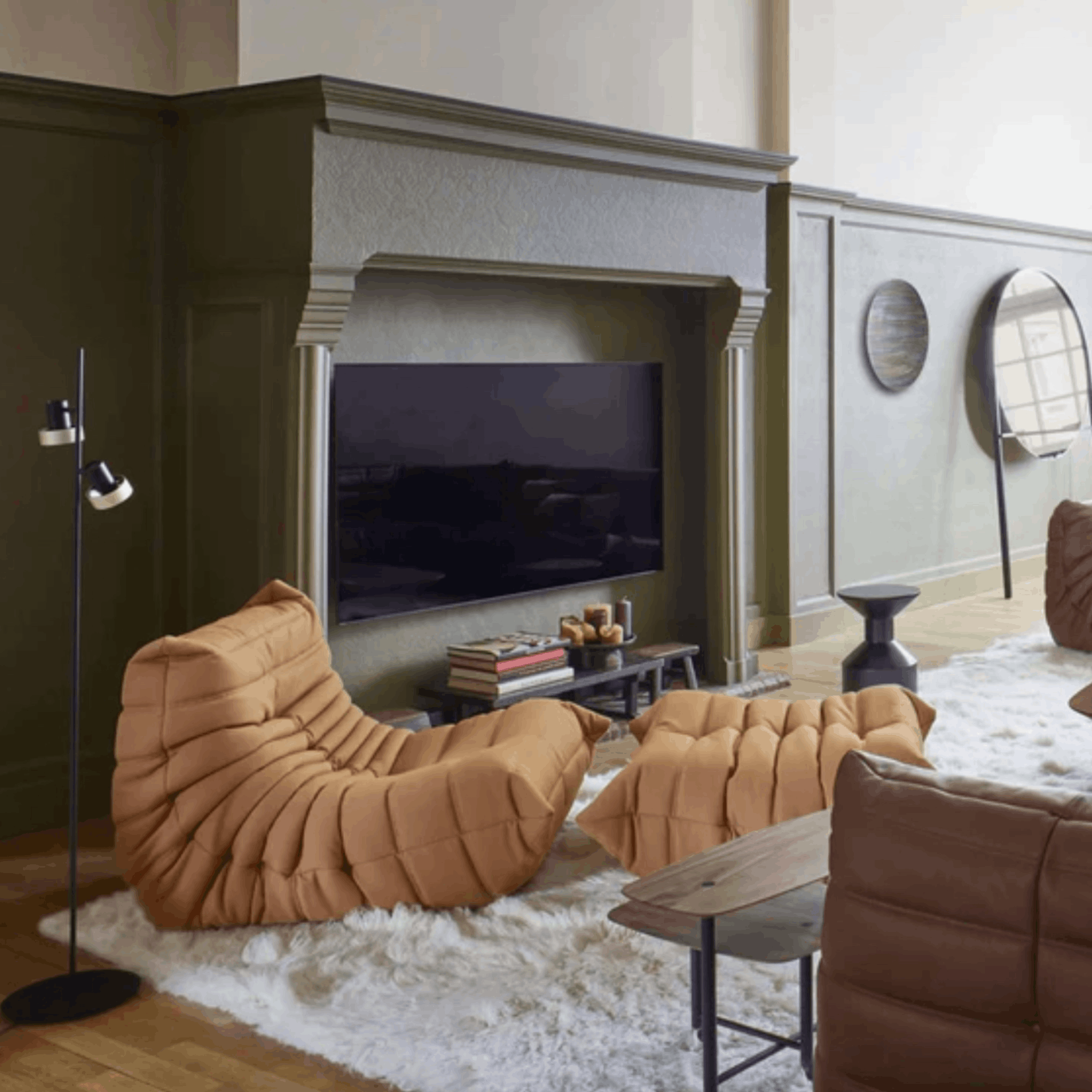 Modern living room with brown lounge chairs, a TV, and decorative items.