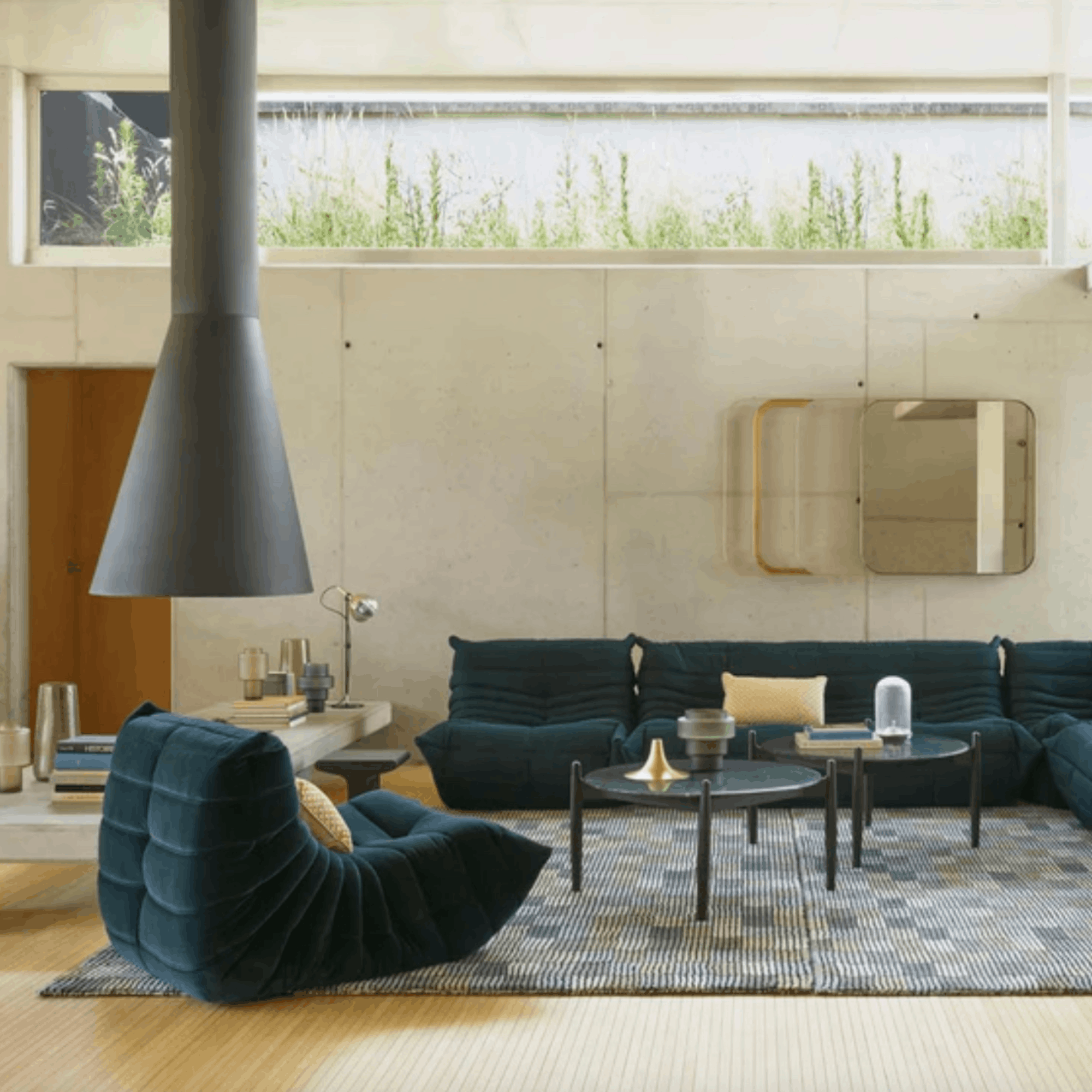 Modern living room with dark blue sofa, armchair, and coffee table.