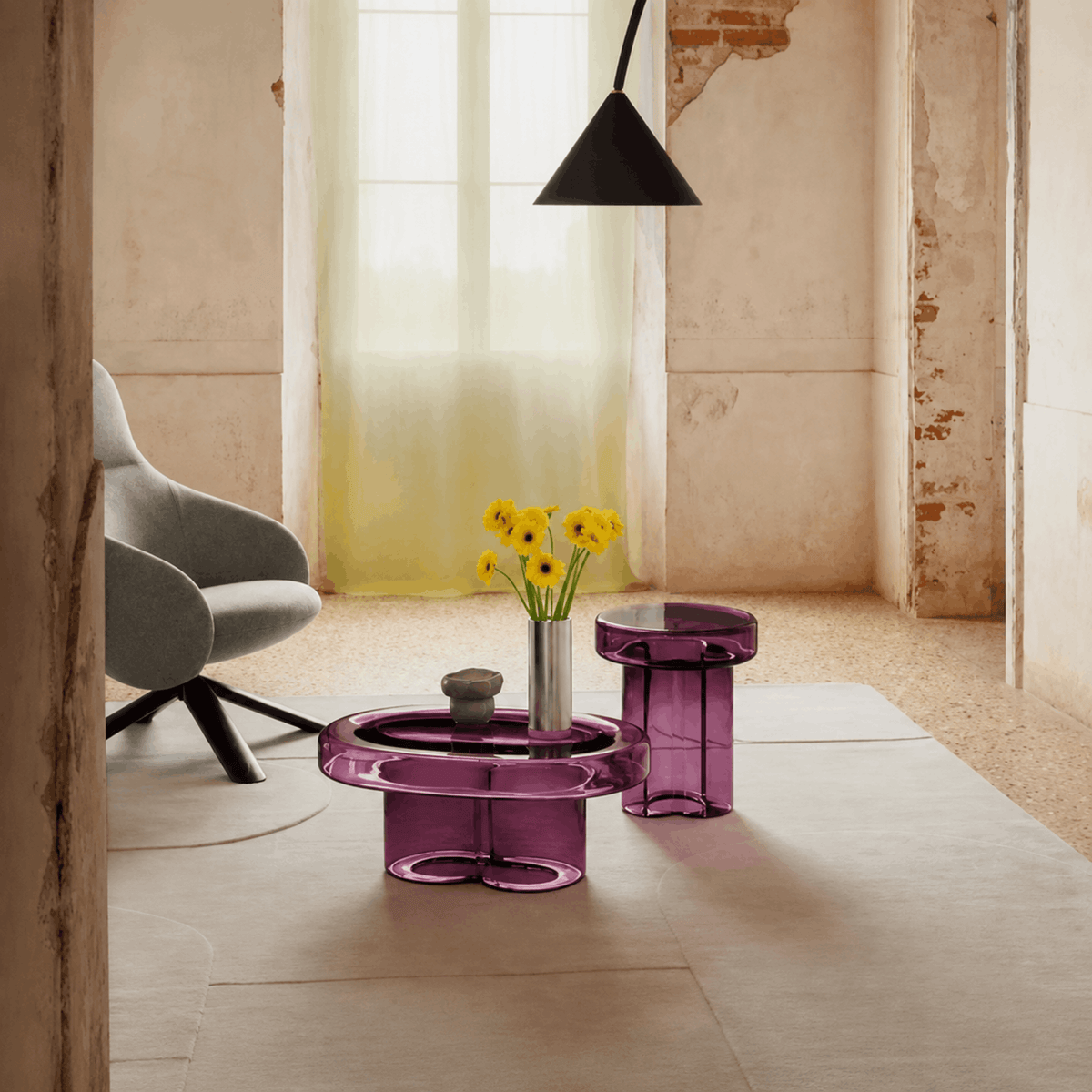Miniforms Soda Oval Coffee Table in purple hand-blown Murano glass with a sculptural base and smooth oval top in a modern, industrial style living room setting.