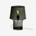 The Muuto Cosy Table Lamp by Harri Koskinen features a sculptural mushroom-shaped design crafted from smoked grey mouth-blown glass. With soft diffused light and mains dimming compatibility, it brings warm Scandinavian style and ambient lighting to contemporary interiors.