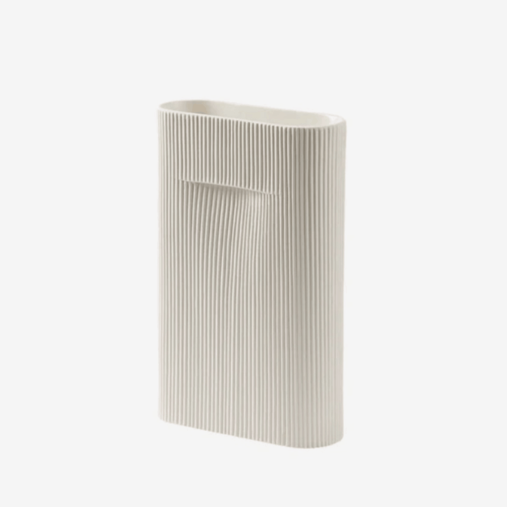 The Muuto Ridge Vase is a contemporary earthenware vase featuring a distinctive sculptural silhouette and innovative central indentation that supports floral arrangements while doubling as a practical handle. Perfect as a statement decorative object or elegant vase for modern Scandinavian interiors.