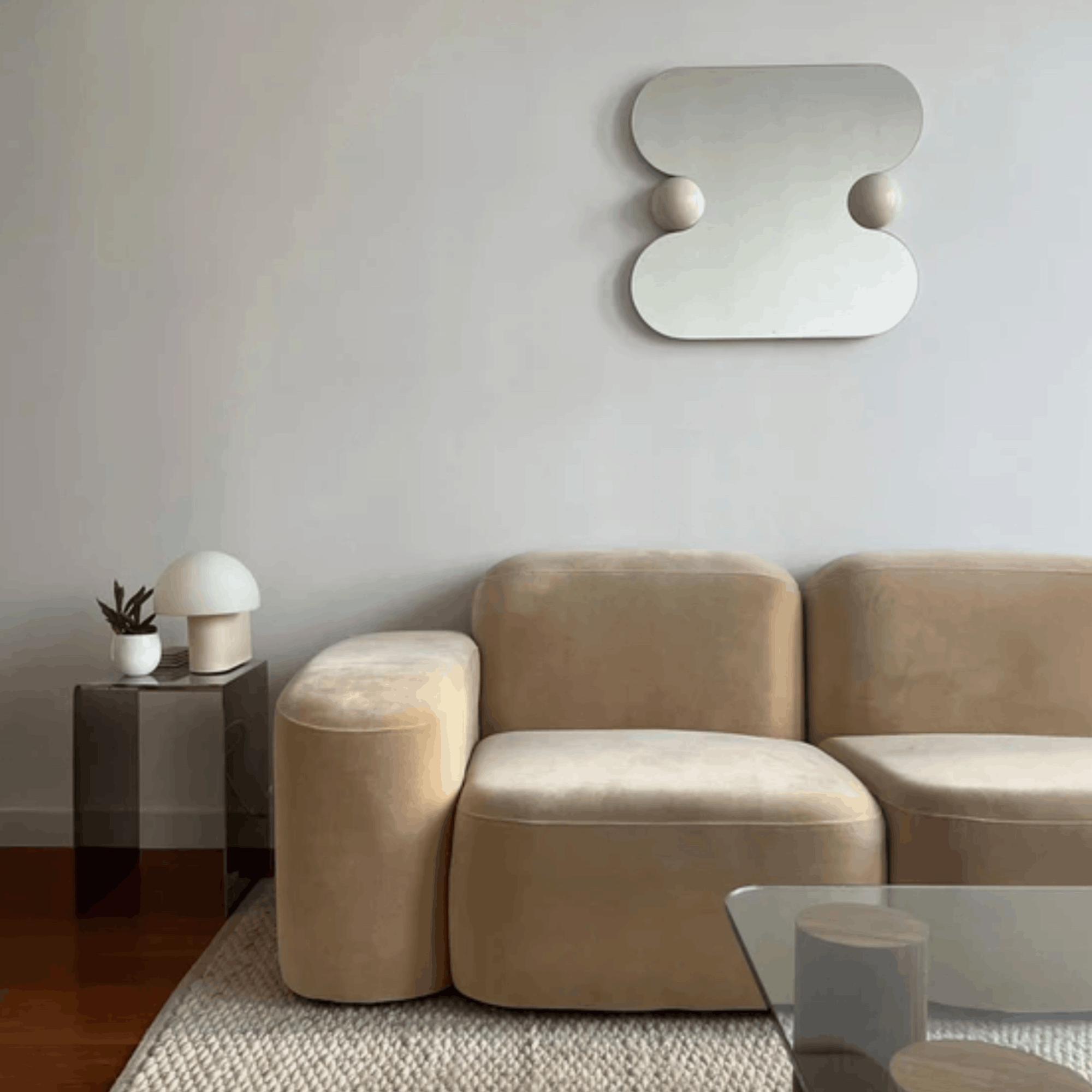 The Ready To Hang Squeeze Mirror hanging on a white above a modern beige sofa in a contemporary living room.