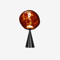 The Tom Dixon Melt LED Cone Fat Table Lamp features the iconic copper Melt shade mounted on a sleek black cone base. With integrated dimmable LED lighting, warm 3000K illumination and a sculptural metallic finish, it creates a dramatic statement in contemporary interiors.