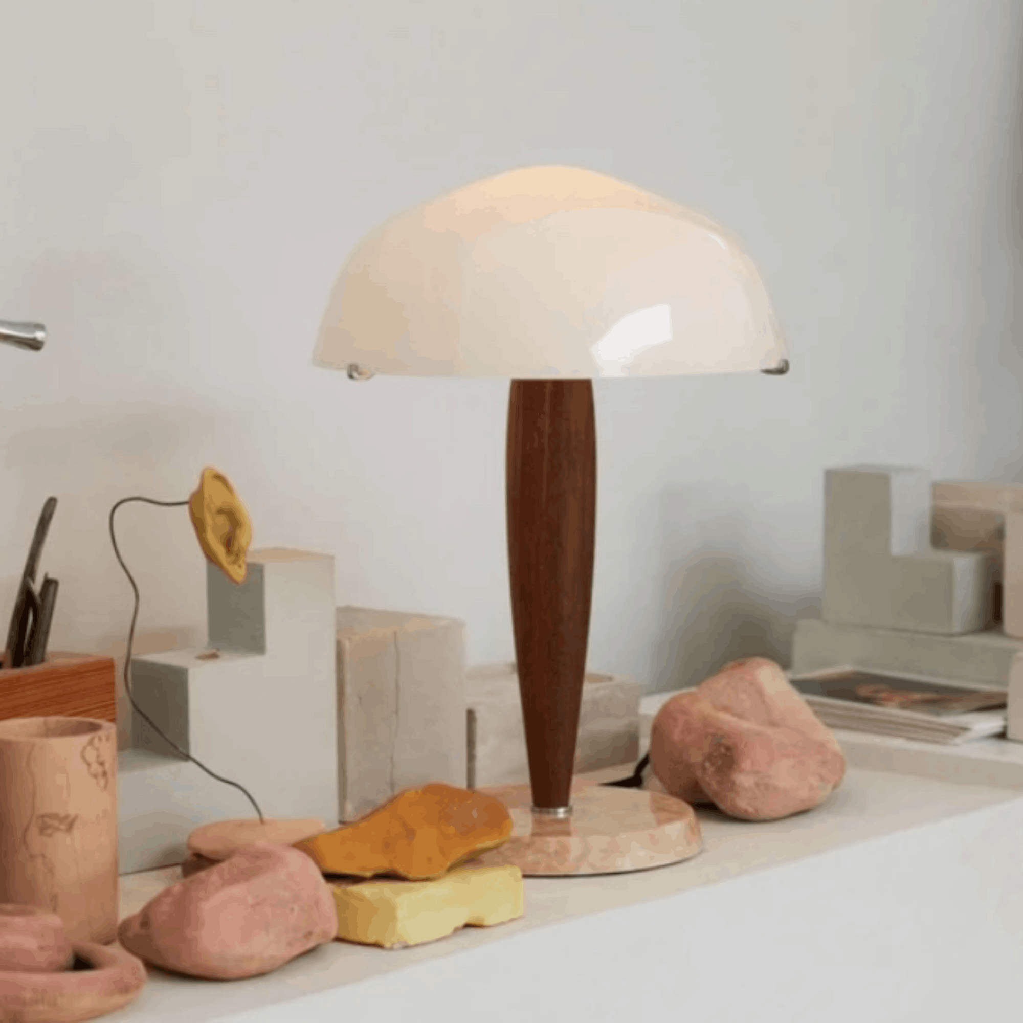 &Tradition Herman SHY3 table lamp with opal glass shade and marble base styled on a white shelf with decorative stones and concrete blocks.