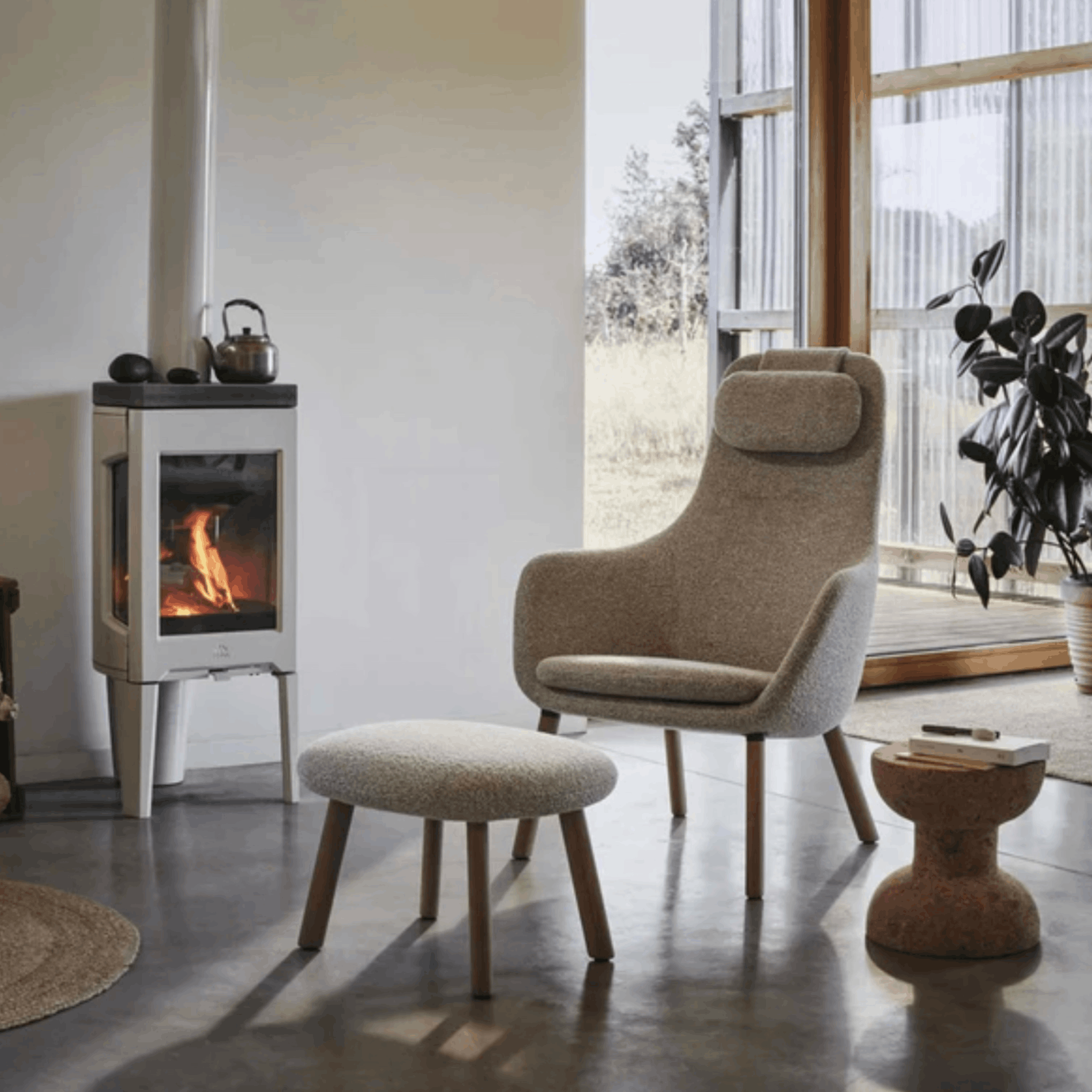Modern living room with a fireplace, chair, and ottoman.